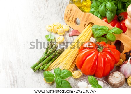 Italian food background. Ingredients for cooking, tomatoes, spaghetti, mushrooms, spaghetti meter on vintage white table. Copy space. Healthy food concept.