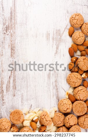 Background with italian almond cookie amaretti and almonds on white vintage table, food concept with copy space, top view.