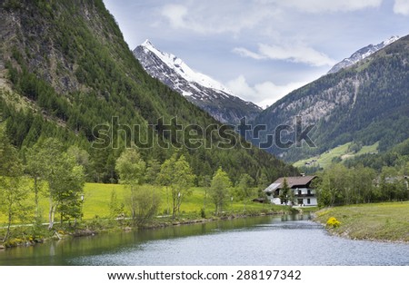 villa on the banks of the river on a background of mountains