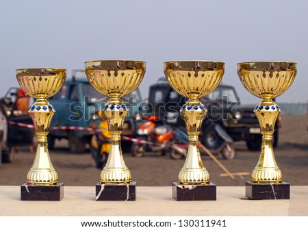 Prize cups on the background of cars