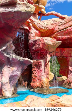 TBILISI, GEORGIA - JULY 03, 2013: Waterfall and unusual red rock in the amusement park \