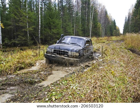 NIZHNY TAGIL. RUSSIA - SEPTEMBER 22, 2012: Russian Plain Road in the heart of Siberia. Flailing at breakneck speed wheel off-road vehicle stuck in a swamp