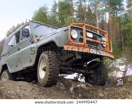NIZHNY TAGIL. RUSSIA - APRIL 27, 2008: Russian Plain Road in the heart of Siberia. Wheel drive vehicle leaves the swamp