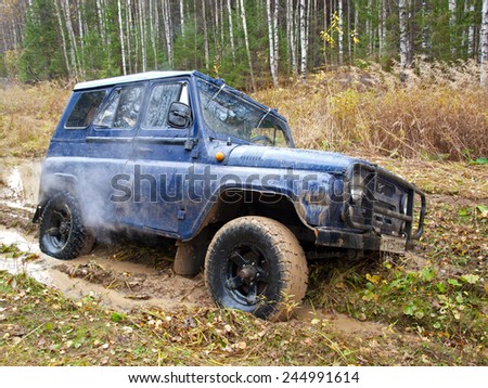 NIZHNY TAGIL. RUSSIA - SEPTEMBER 22, 2012: Russian Plain Road in the heart of Siberia. Wheel drive vehicle leaves the swamp
