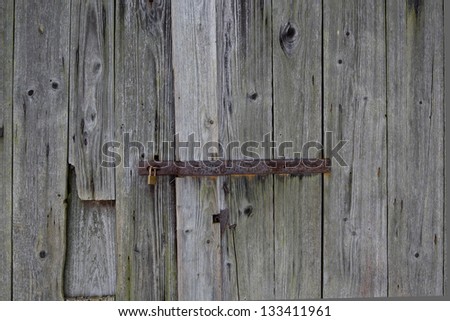 old, used and rusty iron door lock in a wooden door