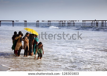 ALLEPY-SEPTEMBER 2012: Many Indian tourists come to the beach for a walk or swim. One of them wants to touch the water with hers hands on september 6, 2012 in Allepy, India.