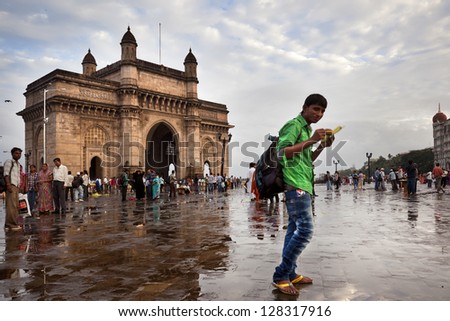 MUMBAI-AUGUST 2012: The Gateway of India is a popular hangout for Indian tourism. Families stroll and taking pictures. They eat cobs offered in small stalls on august 28, 2012 in Mumbai, India.