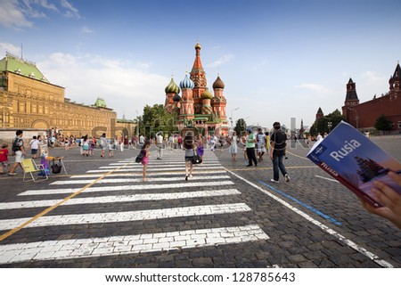 MOSCOW-JULY 20: As a tourist stops to read their guide. Dozens of travelers, walk through Red Square and a chance to visit and photograph the cathedral St. Basil on july 20, 2010 in Moscow, Russia