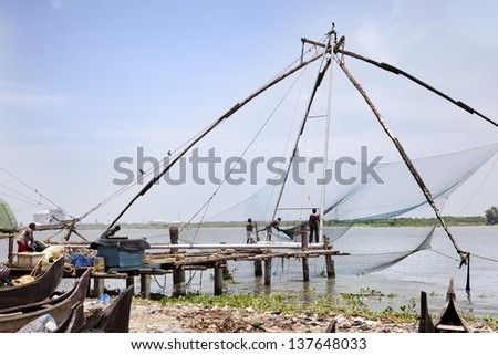COCHIN-SEPTEMBER 05: Men work in the Chinese fishing net. Using ropes, they hold the counterweights that allows them to get on and off the fishing net on september 5, 2012 in Cochin, Inda