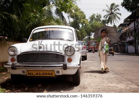 COCHIN-SEPTEMBER 5: Three things are very typical in India as warm, sharis and the Hindustan Ambassador car. A woman protected with her umbrella in the streets of Cochin on september 5, 2012 in India