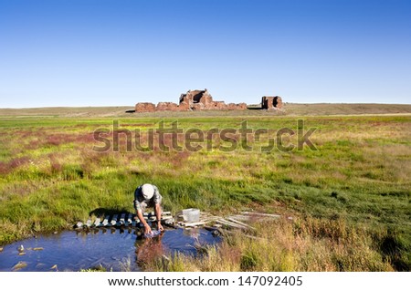 GOBI DESERT-AUGUST 3: There are not many natural springs in the Gobi Desert. A Mongolian collect fresh water from a spring at the back of a ruined palace on august 3, 2010 in Gobi desert, Mongolia