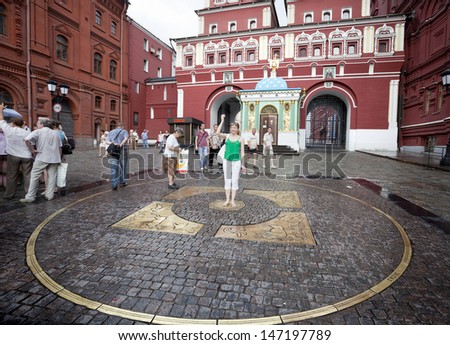 MOSCOW-JULY 20: A girl throws a coin back while making a wish on one of the entries in the Red Square in Moscow on july 20, 2010 in Russia
