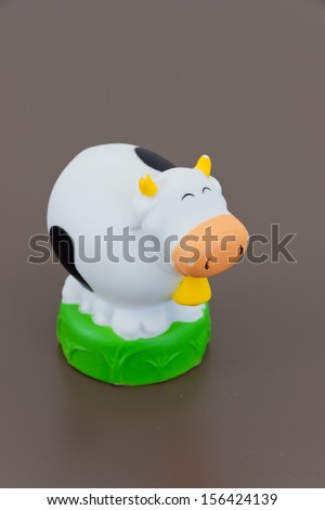 Plastic toy cow isolated on grey background