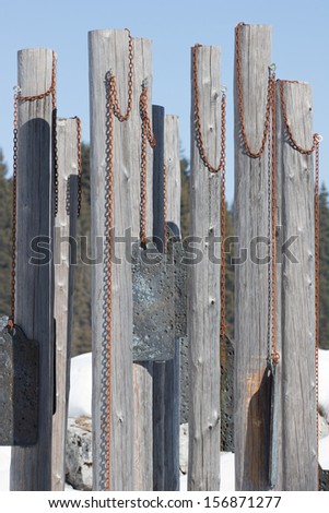 Memorial to the fallen of World War I on the Italian Alps, consisting of wooden poles with metal plates hung.