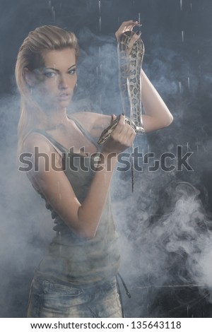 Beautiful Woman in aqua studio with dangerous snake in smoke