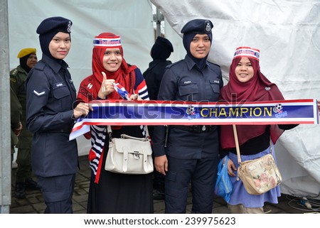 KL,Malaysia-DEC.20:Thai fans cheer poses with the police girls during the competition 2014 AFF Suzuki Cup between Malaysia at Thailand Bukit Jalil stadium on December 20, 2014 in Kuala Lumpur,Malaysia