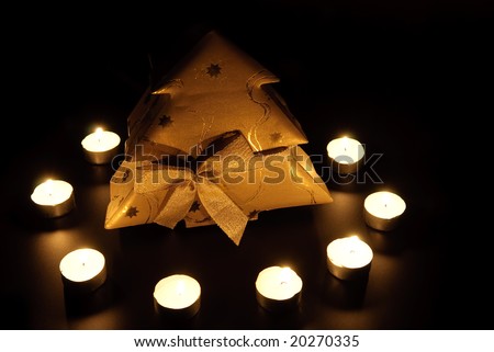 Christmas candle and gift box on black background