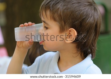 Close up of a young boy drinkin cup of water