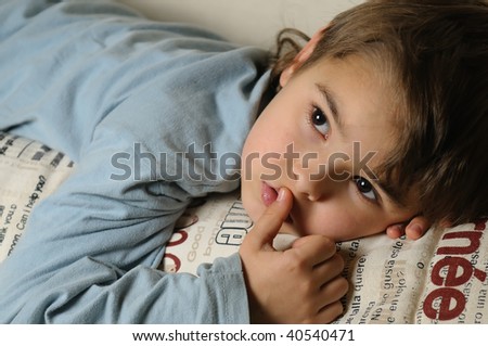 boy lying on the bed and watching tv