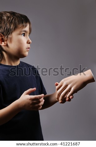 surprised boy shaking mannequin's hand