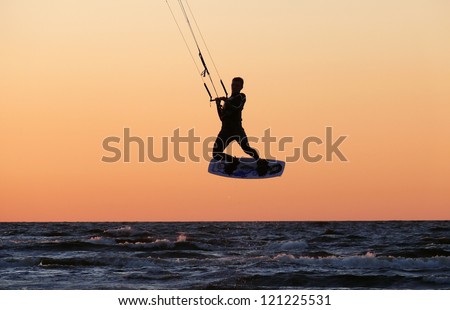 kite boarding aerial jump silhouette, with sunset background.