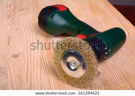 Screwdriver with a nozzle for the treatment of wooden surface