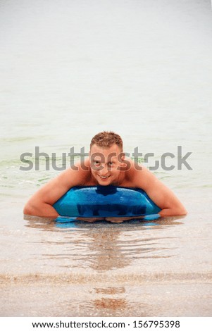 man in water floating on inner tube