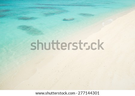 Clear blue coral water meets perfect white sand beach paradise in Asia