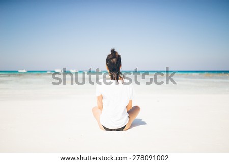 Female tourist relaxing on idyllic tropical beach paradise in Koh Tachai, Thailand