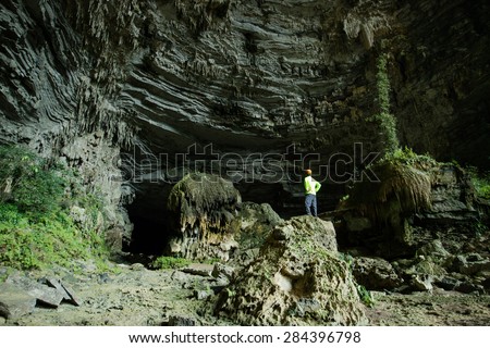Man exploring huge underground cave in Tu Lan, Vietnam