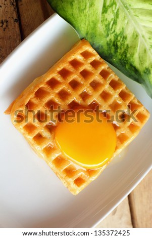 Waffle topped with eggs.