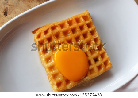 Waffle topped with eggs.
