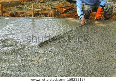 Pouring concrete mix for road construction workers.