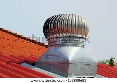 stainless steel exhaust fan on roof with blue sky