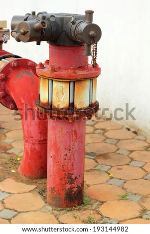 red rusty metal industrial water pipes with a valve.