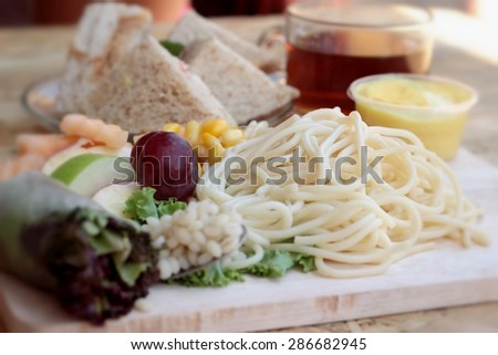 Pasta spaghetti with salad mix fruit and bread sandwich.