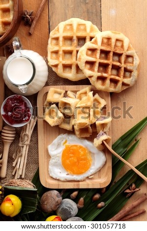 Sweet waffles and fresh milk with jam and egg heart