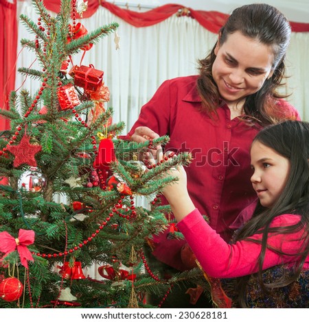 Family decorating Christmas tree At Home