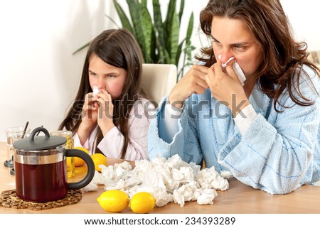 Mother and daughter having tea, eating lemon, honey to heal
