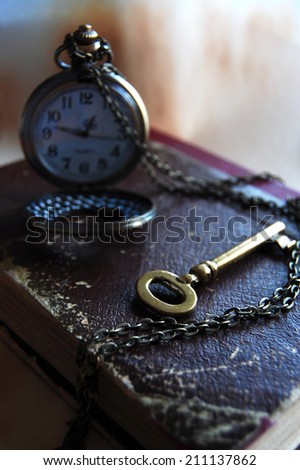 Vintage Key, Book and Pocket Watch. The Key is in Time