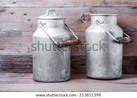 Aluminum old milk cans on a wooden background