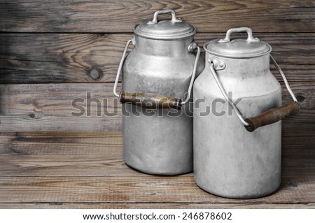 Aluminum old milk cans on a wooden background in the horizontal format