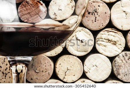 Close-up of red wine glass on wine corks background in the horizontal format