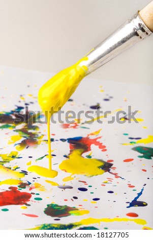 Paintbrush with yellow paint dripping