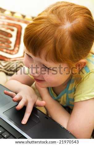 Redheaded girl having fun with computer game