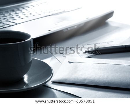 Laptop, coffee, papers and pen