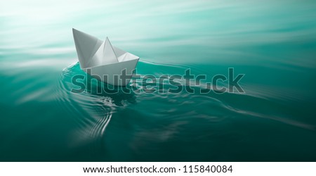 origami paper boat sailing on water causing waves and ripples