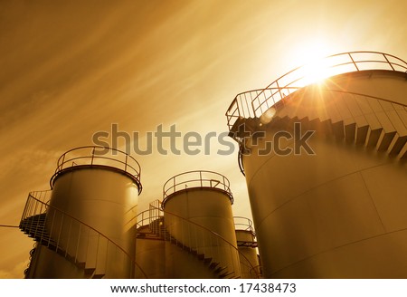 chemical plant\'s storage tanks at sunset hour