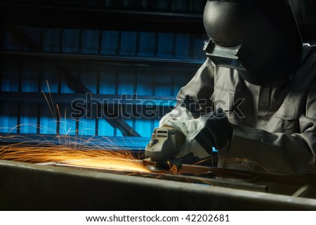 man grinding in workshop with safety precaution