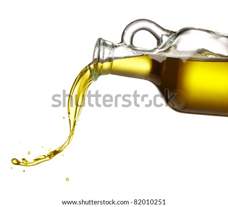 pouring olive oil from glass bottle against white background pouring olive oil from glass bottle against white background